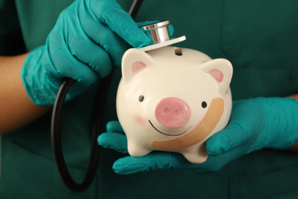 Veterinarian checks the pulse of a piggy bank