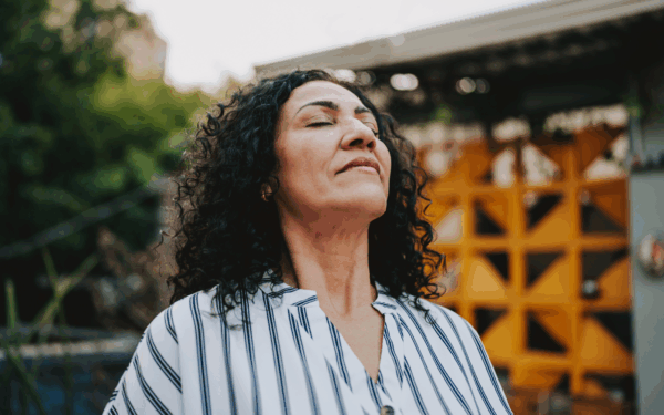 Woman outside with closed eyes looking peaceful redefining financial success